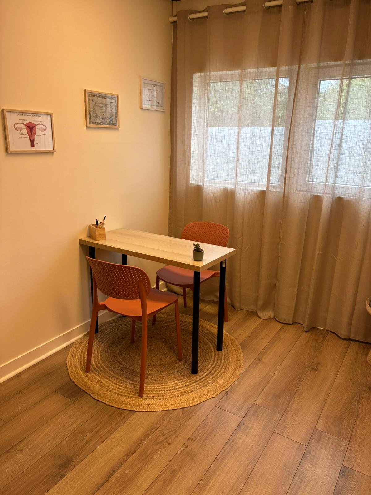 Espace d'échange avec bureau, chaises et diplômes au mur